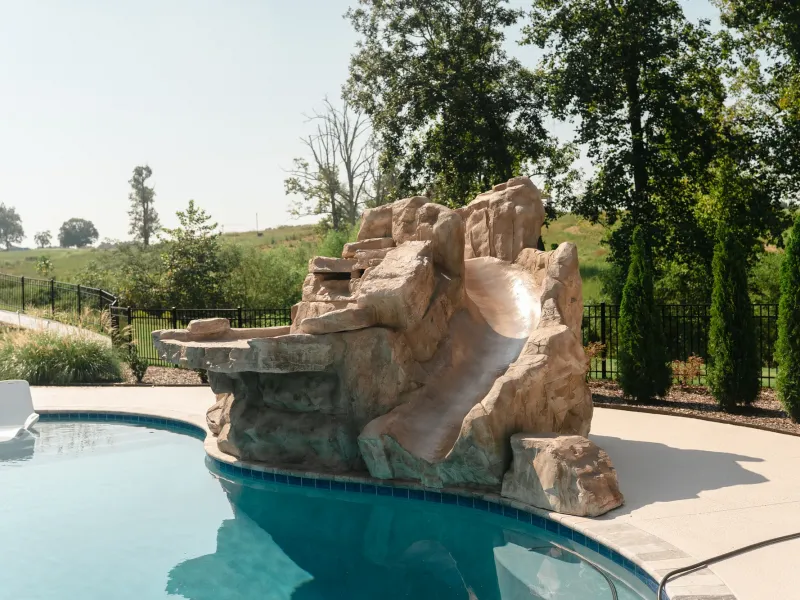 Sculpted rock waterslide and grotto feature built into the edge of a pool in Cullman, Alabama